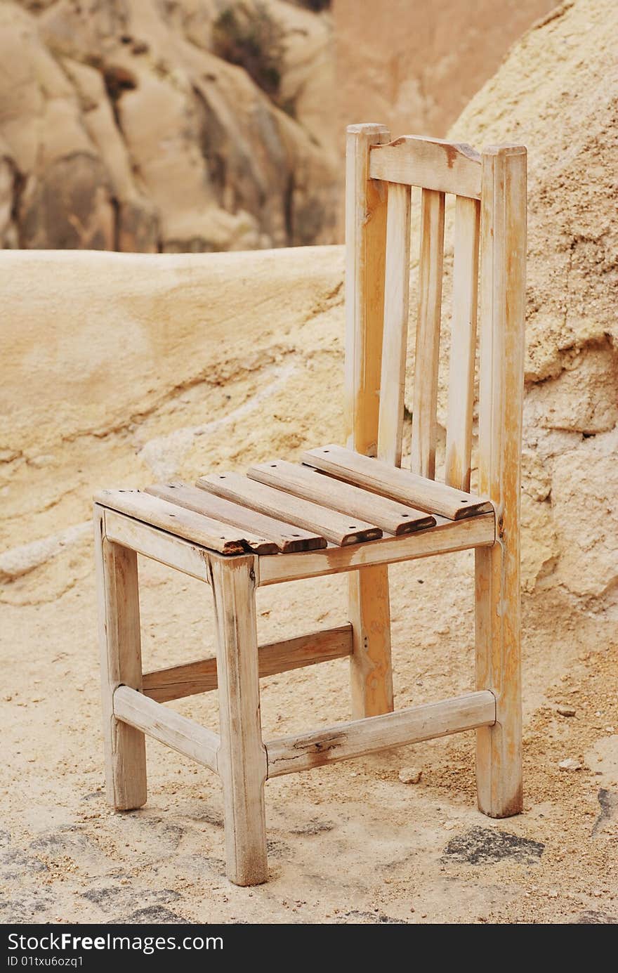 Yellow aged chair on natural rock background. Yellow aged chair on natural rock background