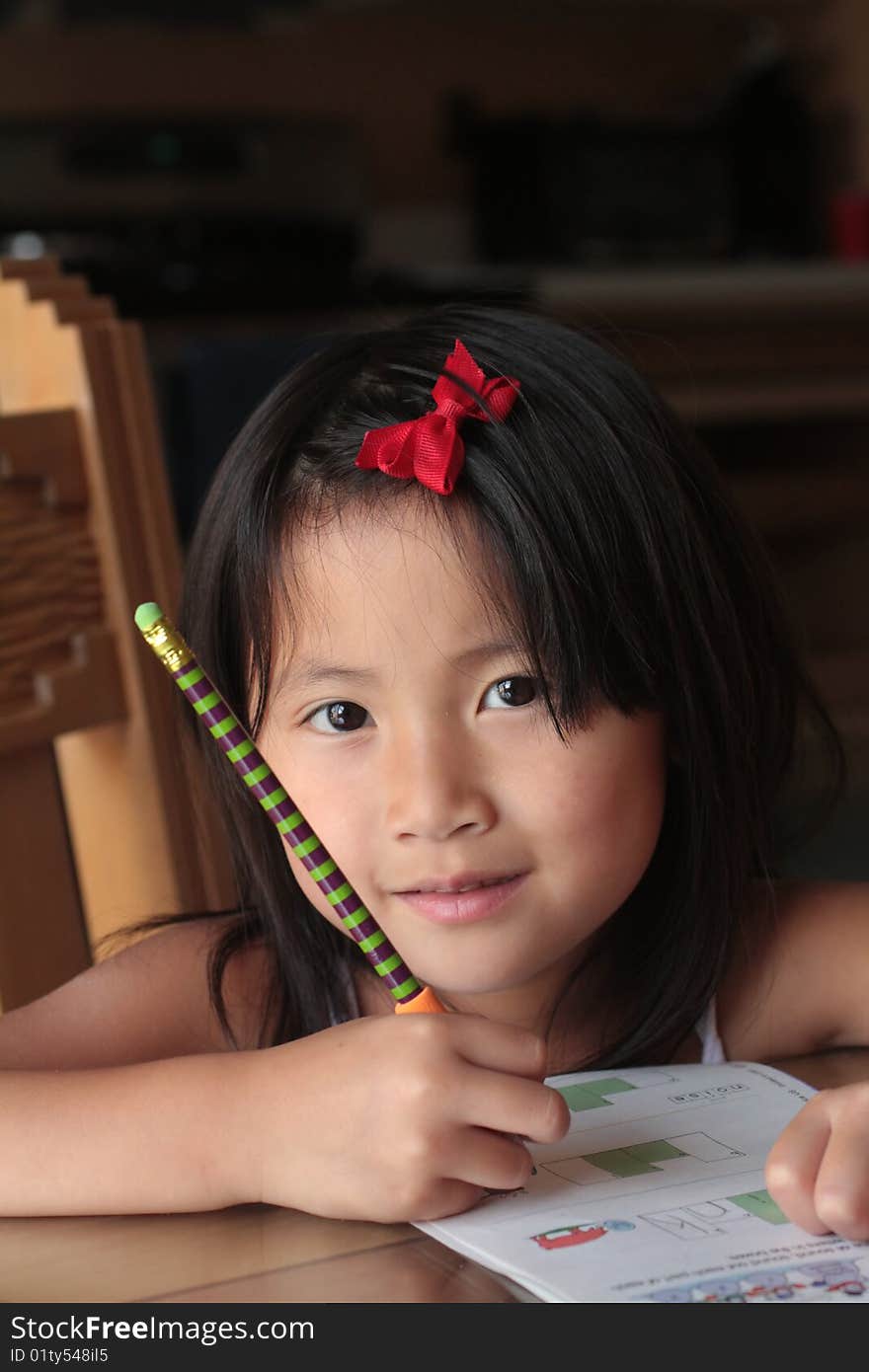 smiling asian girl doing homework