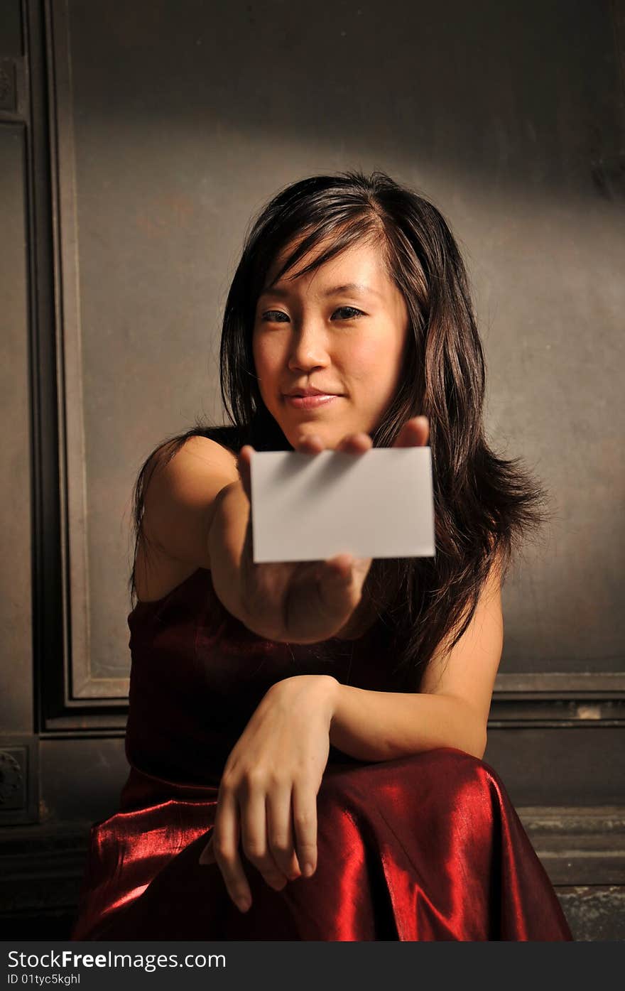 Beautiful young Asian woman in red dress sit and thinking.