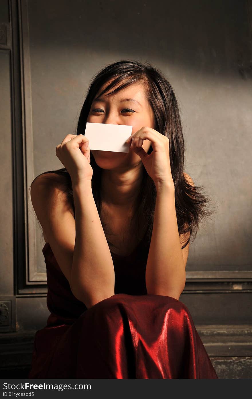 Beautiful young Asian woman in red dress sit and thinking. Beautiful young Asian woman in red dress sit and thinking.