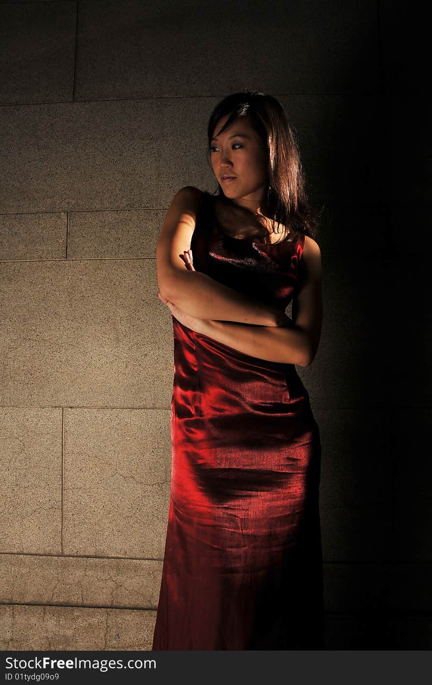 Beautiful young Asian woman in red dress standing or waiting.