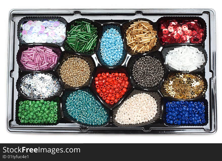 Colour beads in form under sweetmeats on white background