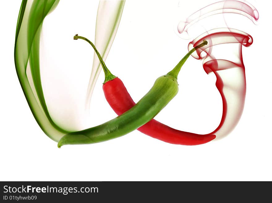 Red and green hot chili pepper with color smoke on white