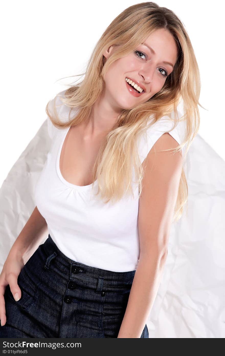 Beautiful blond young woman in blouse and jeans smiling. Beautiful blond young woman in blouse and jeans smiling