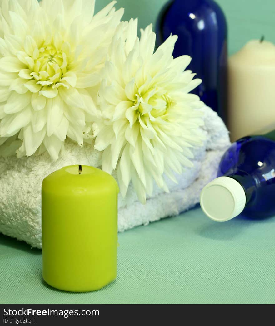 Towel, candles, bottles and flowers.