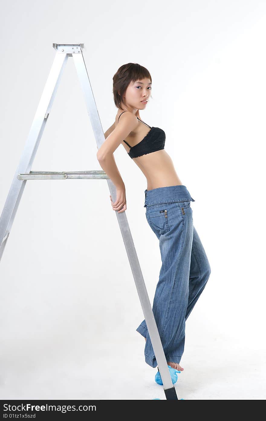 Studio portrait of a beautiful young Asian woman wearing a dress and heels in profile, her face turned toward the viewer. Isolated on a white background. Studio portrait of a beautiful young Asian woman wearing a dress and heels in profile, her face turned toward the viewer. Isolated on a white background.