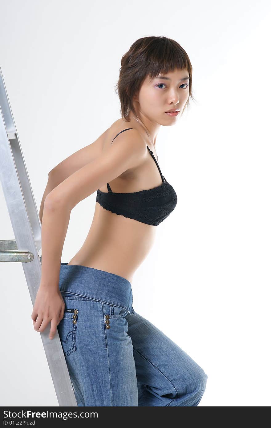 Studio portrait of a beautiful young Asian woman wearing a dress and heels in profile, her face turned toward the viewer. Isolated on a white background. Studio portrait of a beautiful young Asian woman wearing a dress and heels in profile, her face turned toward the viewer. Isolated on a white background.