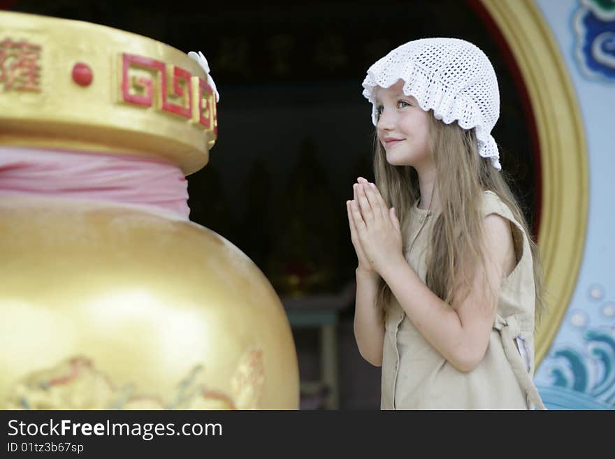 Little girl making a wish in Chineese temple