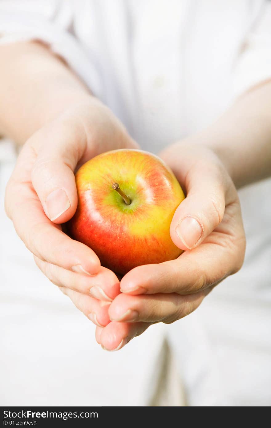 Woman s hands holding a ripe apple