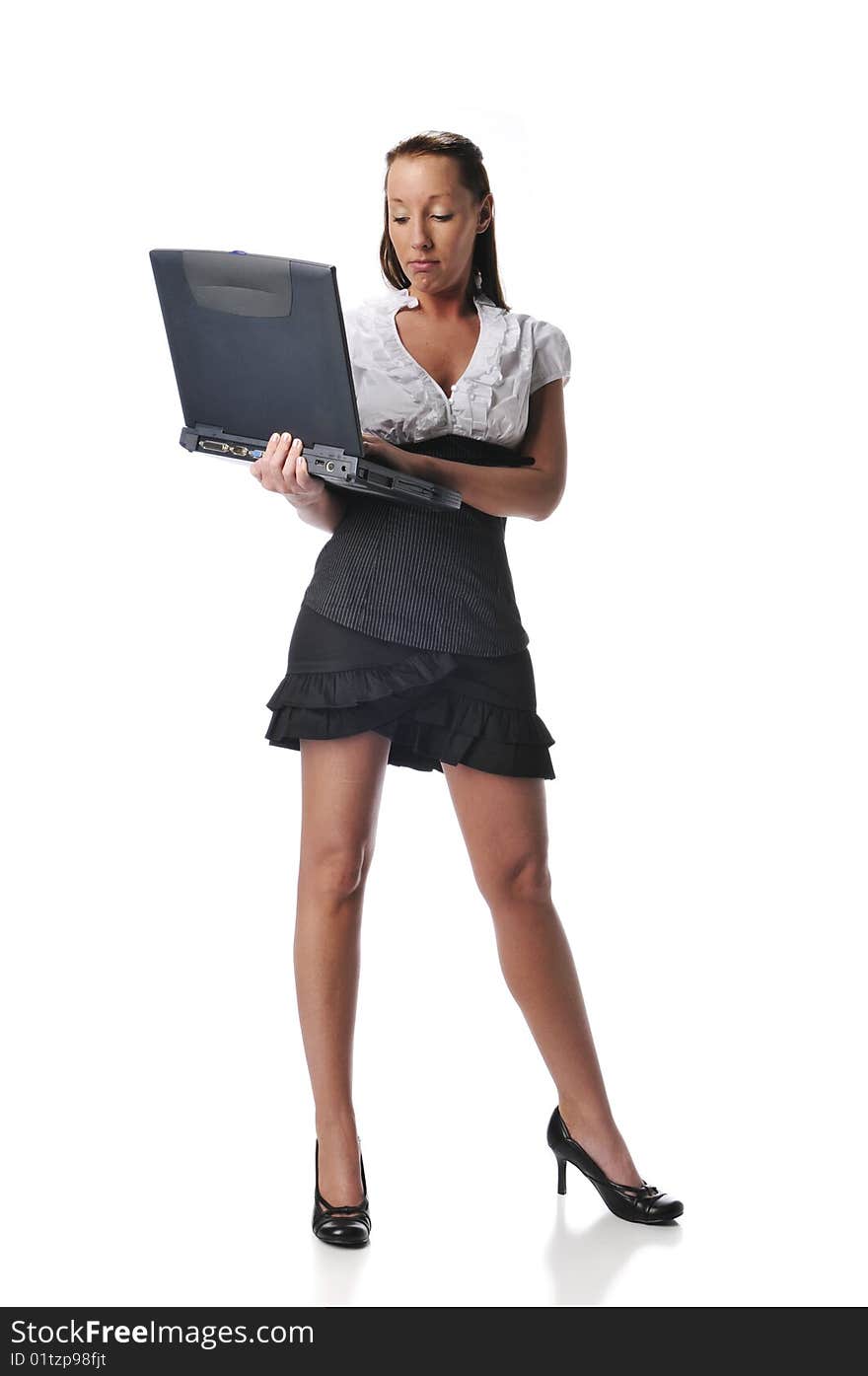 Young woman typing on a laptop standing isolated on a white background. Young woman typing on a laptop standing isolated on a white background