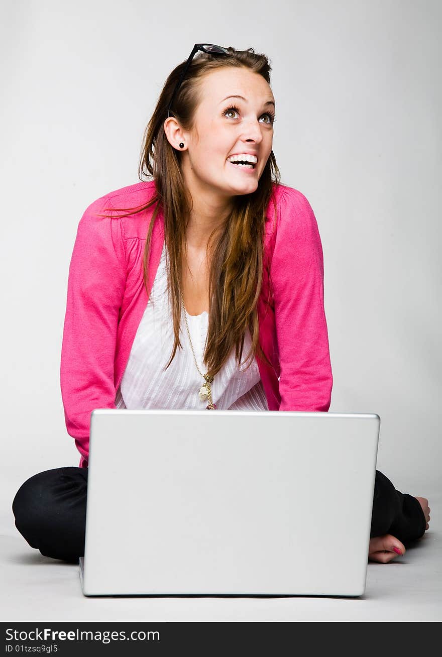 Attractive young woman celebrating with laptop