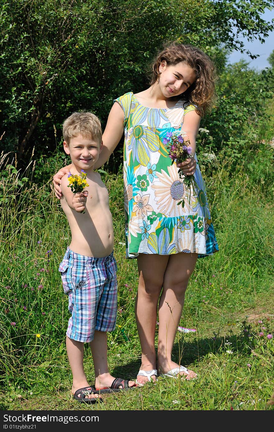 The boy and the girl in solar summer day give you flowers. The boy and the girl in solar summer day give you flowers