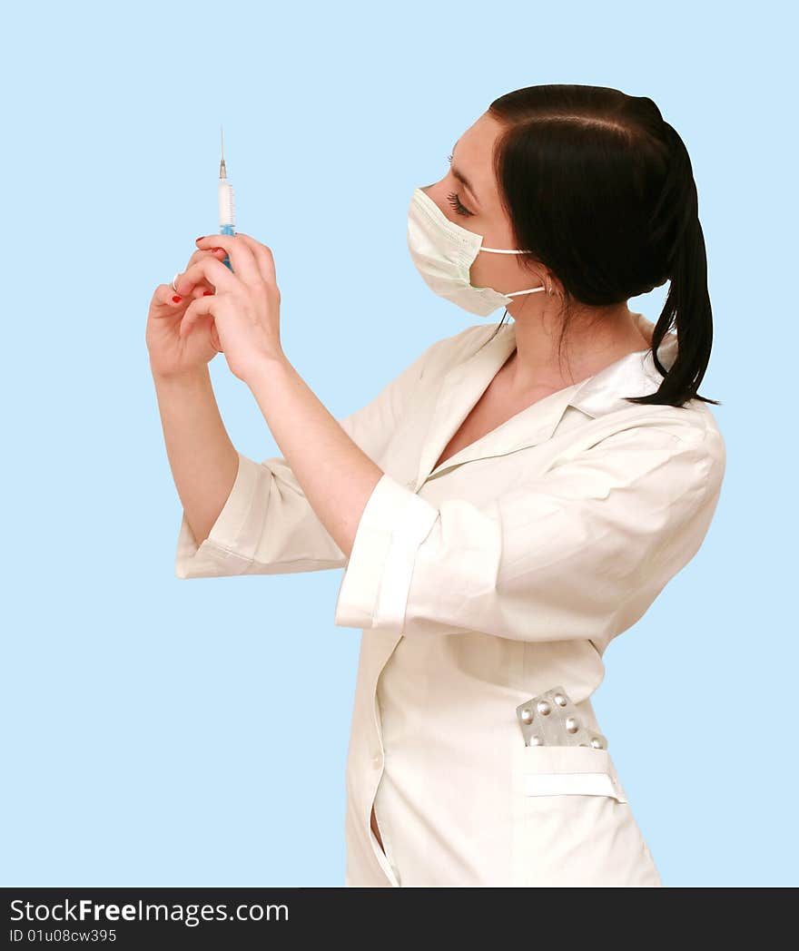 Doctor in a white robe and a mask with syringe