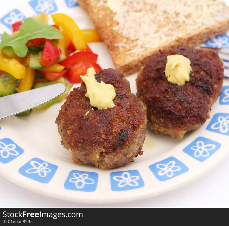 A snack of meatballs with salad of peppers