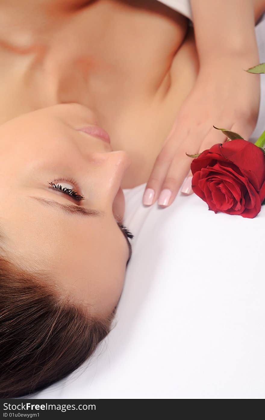 Young pretty woman holding and smelling pink rose petals. Young pretty woman holding and smelling pink rose petals