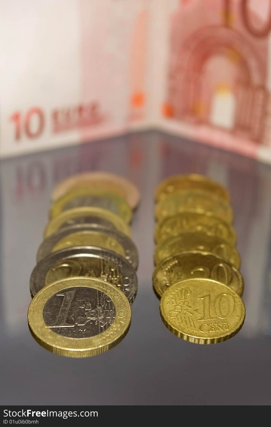 Several coins with euro banknote