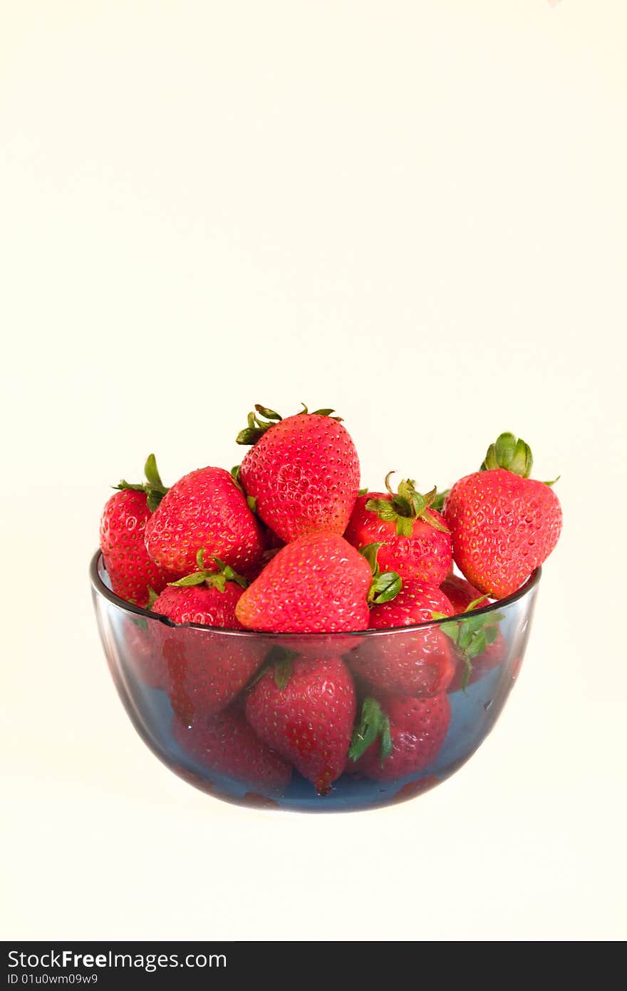 Strawberries in a bowel isoalted on a white background with profile orientation. They are in a clear blue bowel. Strawberries in a bowel isoalted on a white background with profile orientation. They are in a clear blue bowel.