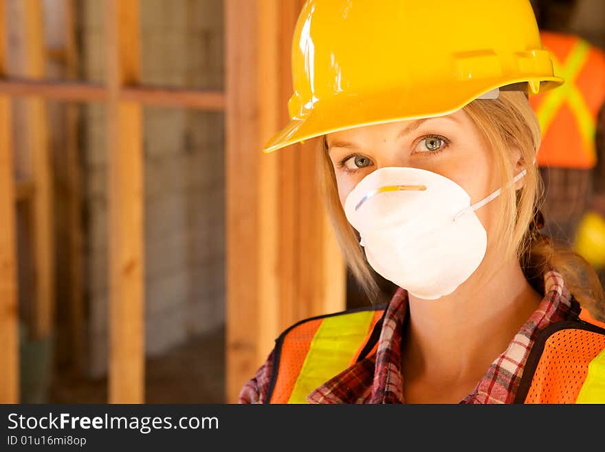 A female construction worker smiling at the camera. A female construction worker smiling at the camera