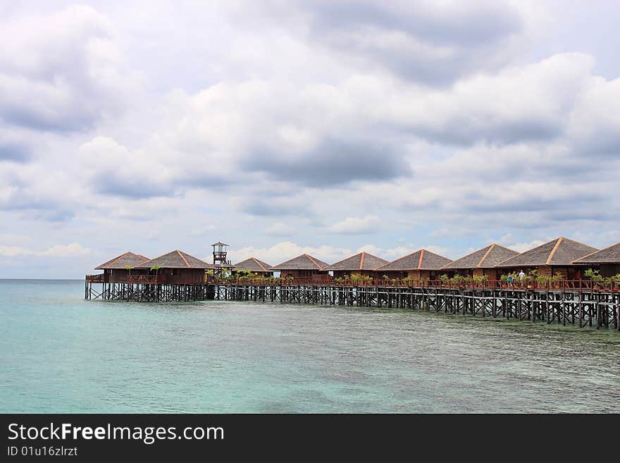 View of Sipdan water village resort at Mabul Island under cloudy day.