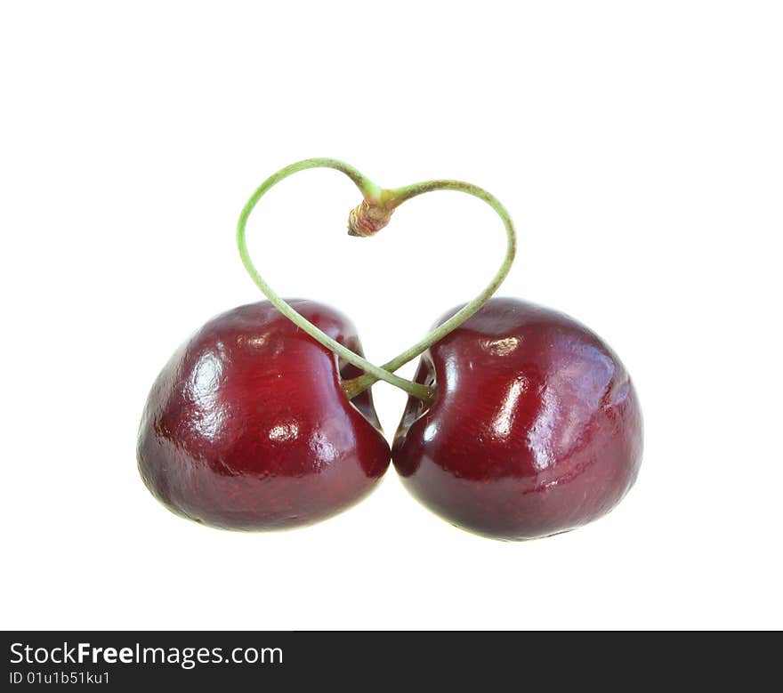 Two sweet cherries and heart on a white background, it is isolated.