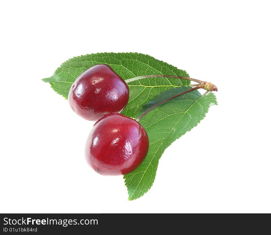 Two sweet cherries with leaves on a white background, it is isolated.