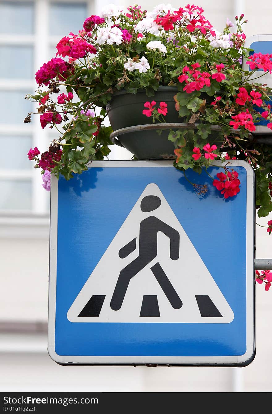 Vertical picture of the crossing sign decorated with beautiful flowers