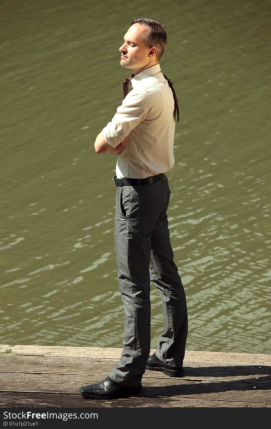 Businessman on the wooden pier enjoying the sun