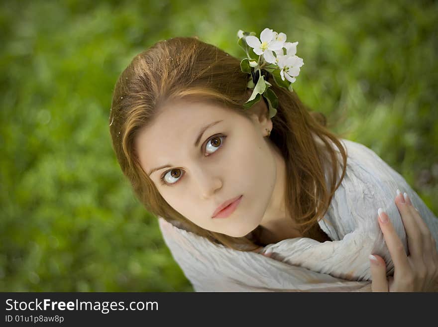 Blurred grass as background, flowers in her hair. Blurred grass as background, flowers in her hair