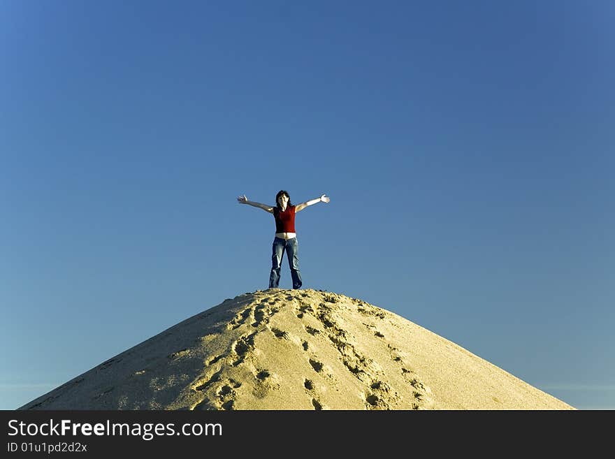 Cheerful Woman On Top Of Sand Hill