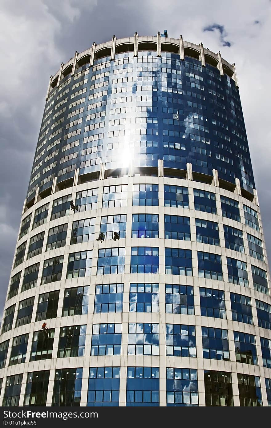 Small human figures on a tower with sky in background. Small human figures on a tower with sky in background