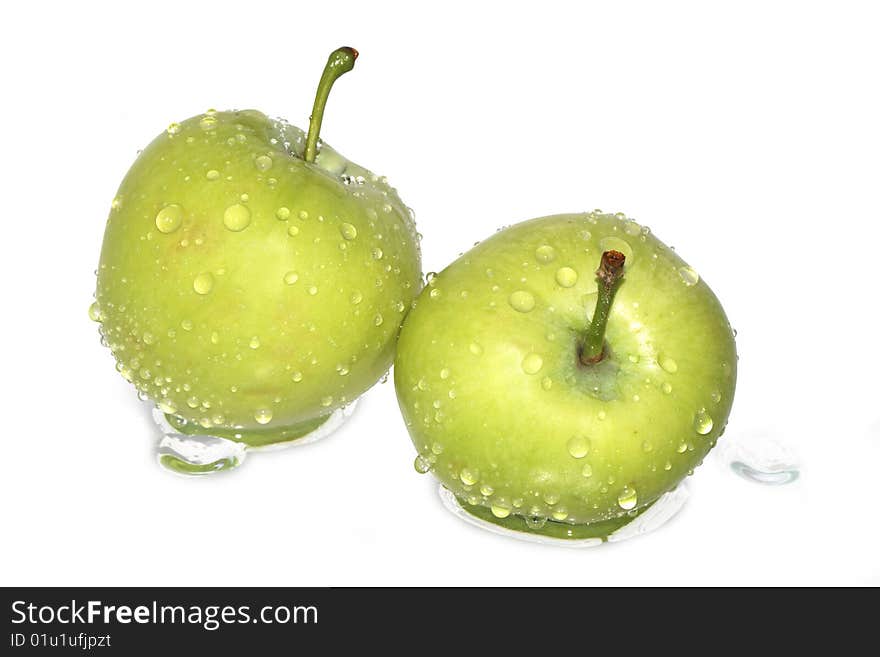 Two fresh green apples under water drops isolated on white background with clipping path