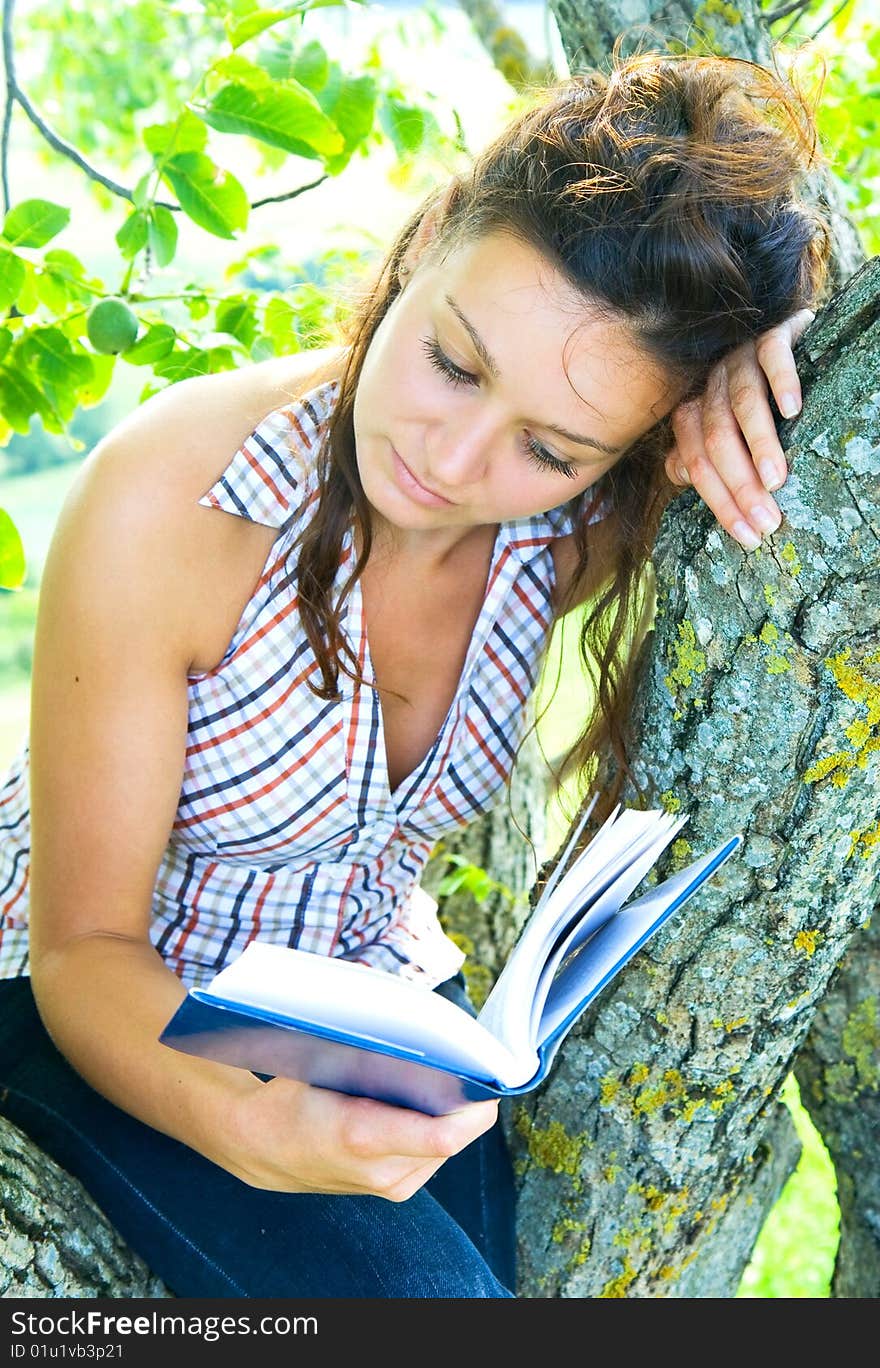 Beautiful girl is reading the book outdoor