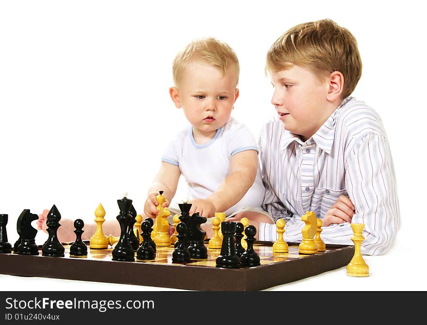 Boy teaching chess to little brother