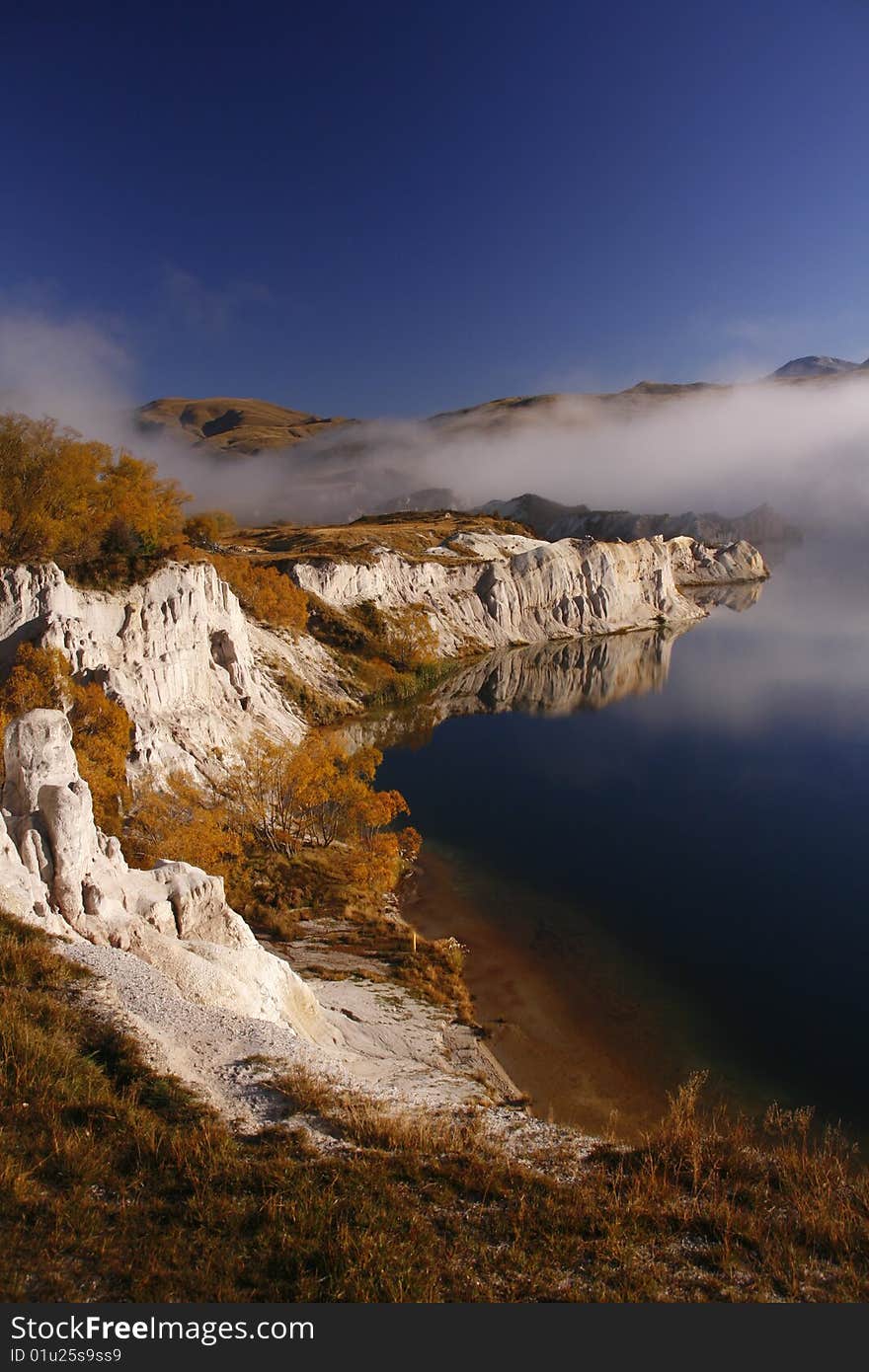 The misty lake of St Bathans, New Zealand on a beautiful, autumn morning.