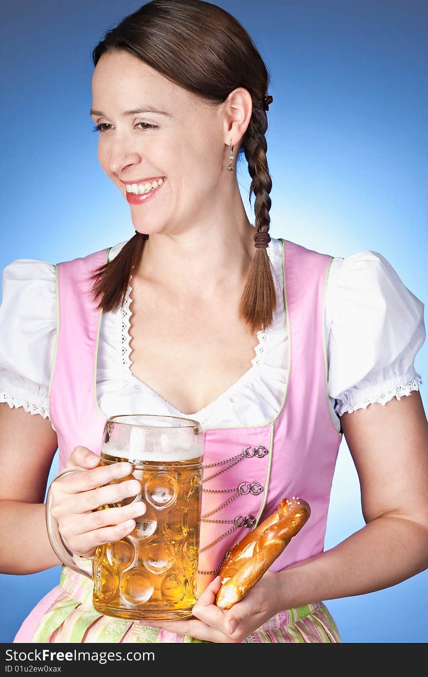 A young Bavarian girl in a Dirndl holding a beer. A young Bavarian girl in a Dirndl holding a beer.