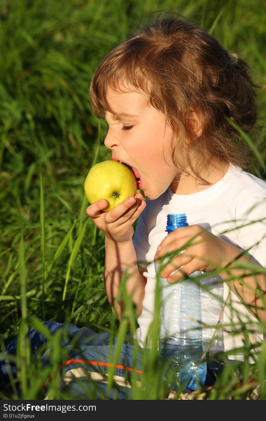 Girl With Plastic Bottle Eats Green Apple