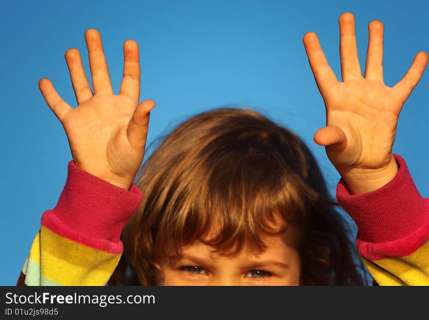 Little girl with lifted hands closeup