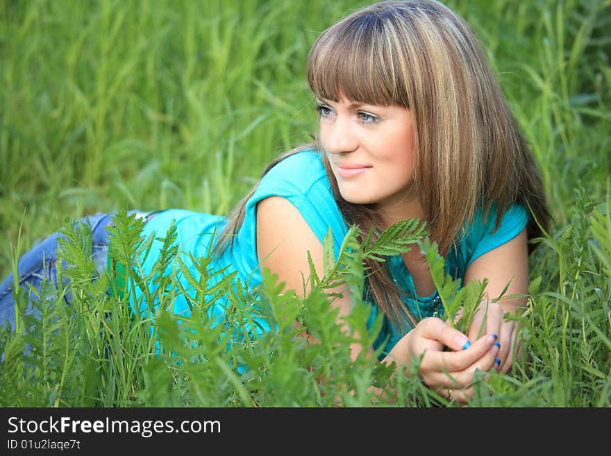 Young beauty girl lies in green grass. Young beauty girl lies in green grass