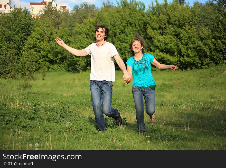 Smiling Pair Runs, Keeping For Hands, In Park