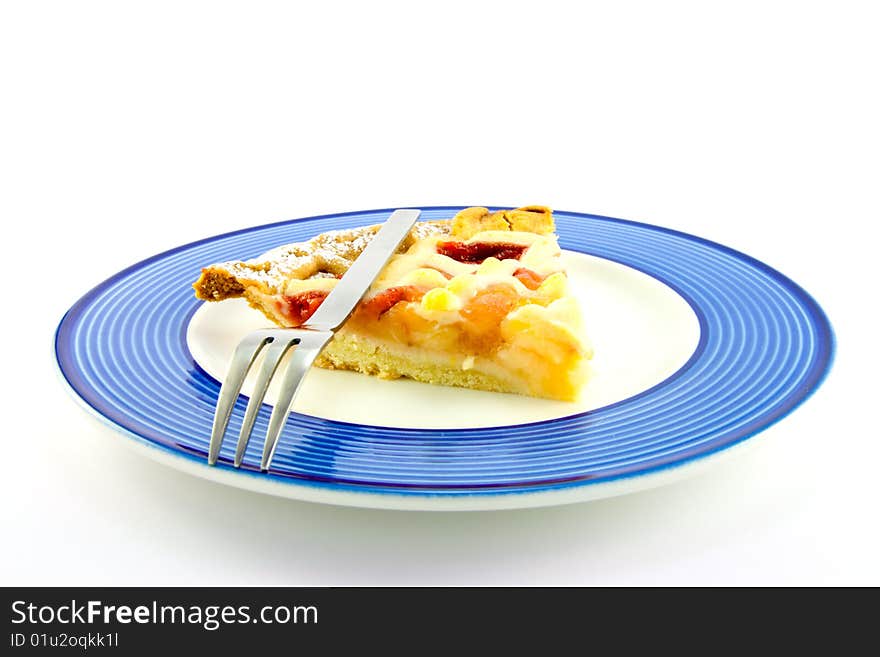 Slice of strawberry and apple pie on a blue plate with a small fork on a white background. Slice of strawberry and apple pie on a blue plate with a small fork on a white background