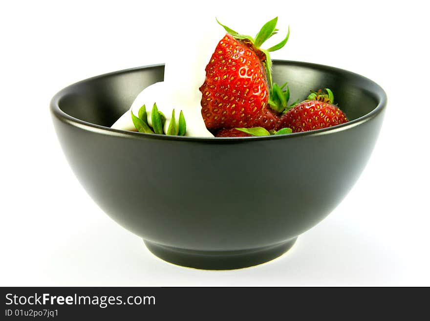 Whole red ripe strawberries with cream in a black bowl on a white background. Whole red ripe strawberries with cream in a black bowl on a white background