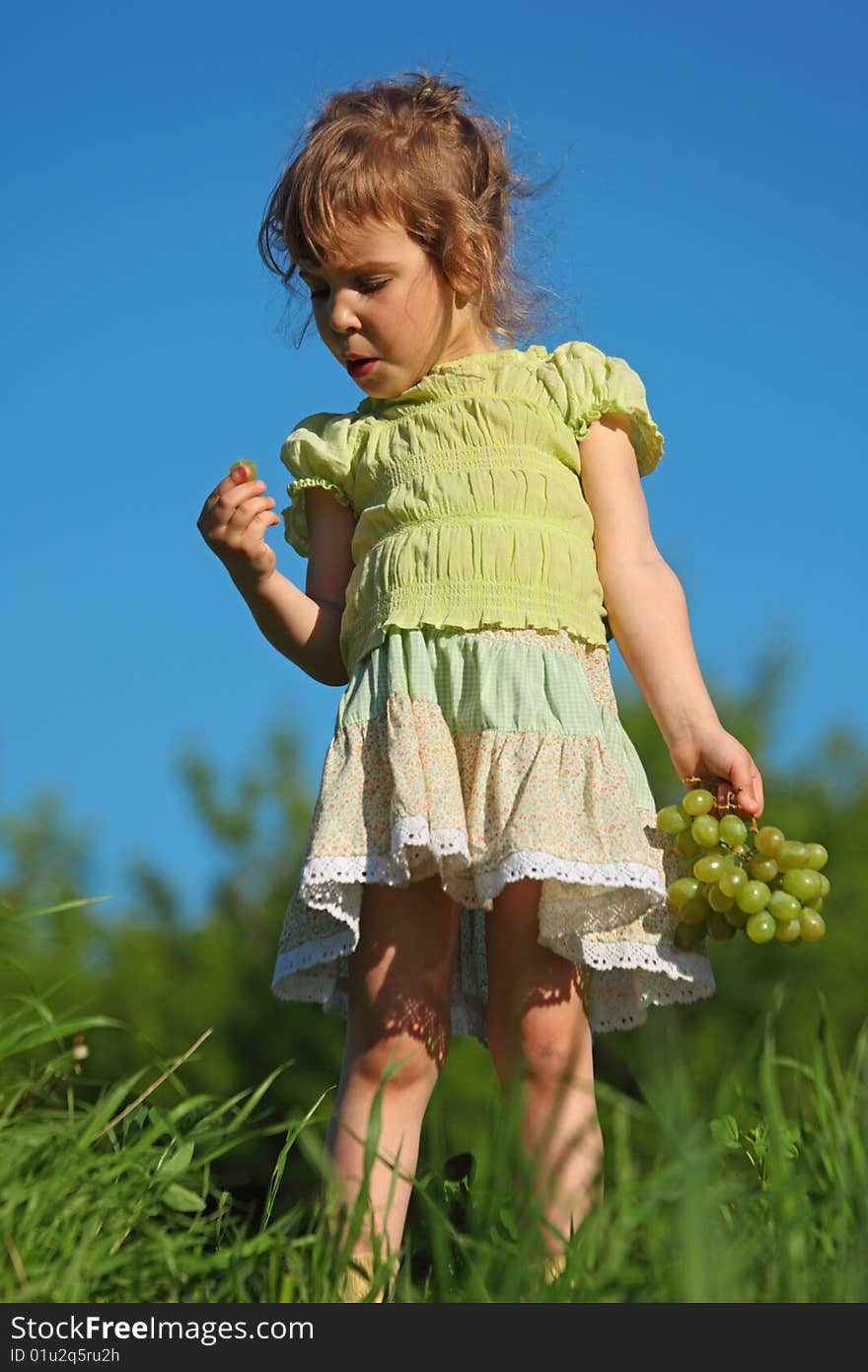 Girl Eats Grape Against Blue Sky