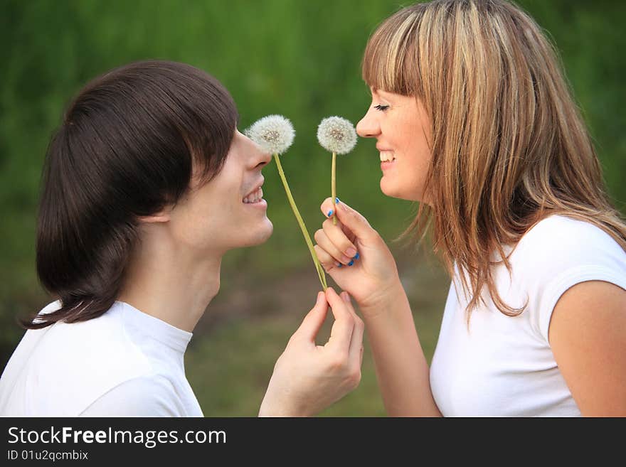 Young pair with dandelions in hands