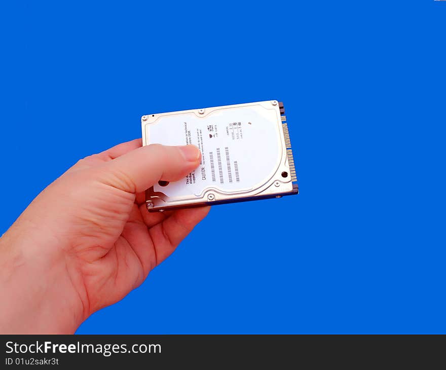 Hand holding 2.5 hard drive for laptops-Blue Background. Hand holding 2.5 hard drive for laptops-Blue Background