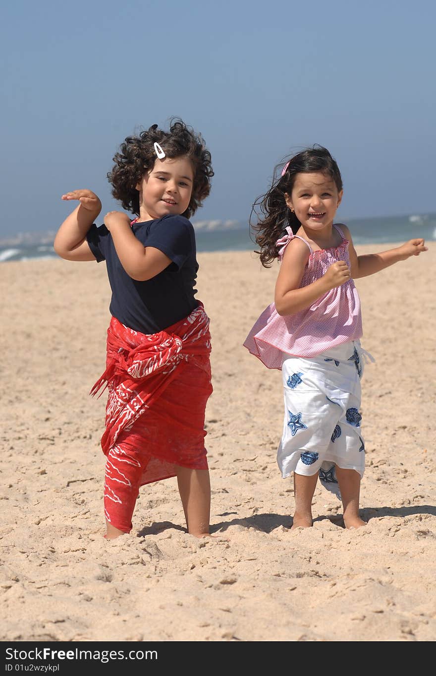 Cute little girls dancing on the beach