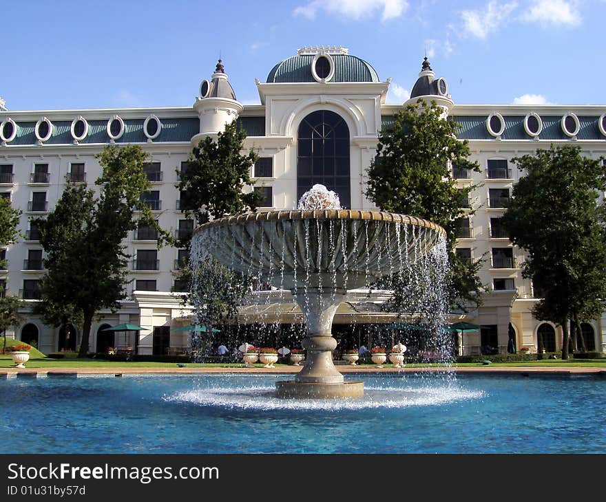 The hotel fountain in the middle of the pool with the hotel facade in the background. The hotel fountain in the middle of the pool with the hotel facade in the background