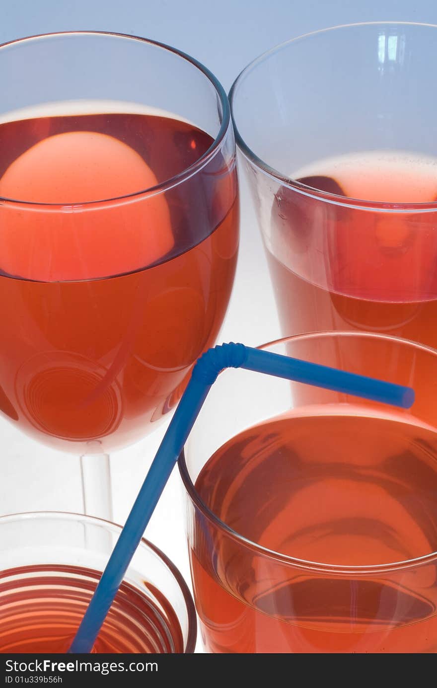 A couple of glasses filled with red, transparent juice or wine. A couple of glasses filled with red, transparent juice or wine.