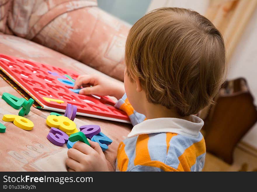 Young boy with plastic numbers.