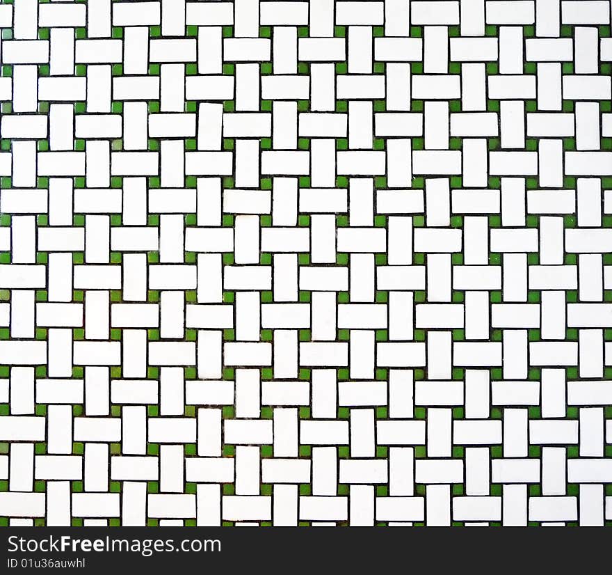 Top down image of vintage green and white floor tiles with a weave pattern. Top down image of vintage green and white floor tiles with a weave pattern.