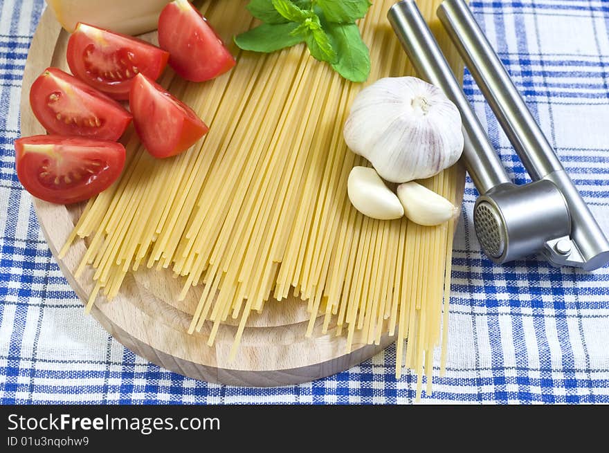 Raw Spaghetti with Red Tomatos and Garlic On Kitchen Table. Raw Spaghetti with Red Tomatos and Garlic On Kitchen Table